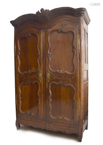 Good early 19th century French oak armoire, with a shaped pediment over panelled doors with brass