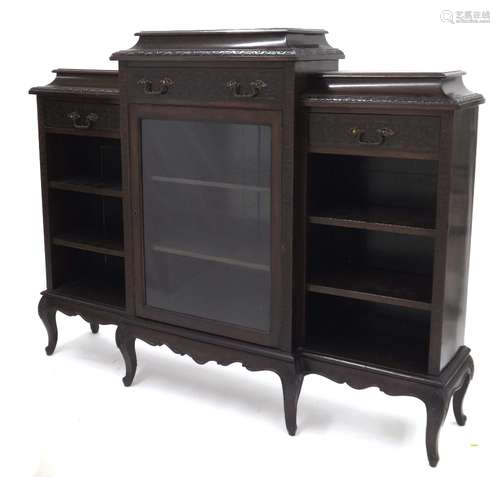 Carved mahogany breakfront bookcase, the caddy tops over frieze drawers above open shelved sections,