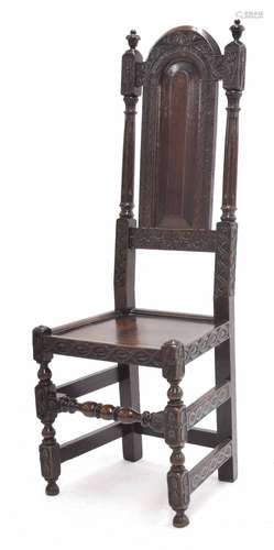 17th/18th century oak high back hall chair, with an arched fielded panelled back within carved