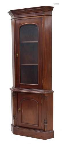 Mahogany glazed standing corner cabinet, the shaped cornice over arched glazed door enclosing a