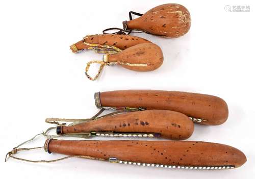 Collection of African gourd flasks, three long, with shell mount leather strapping, and three