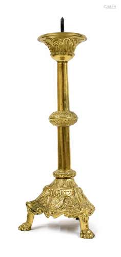 Antique brass ecclesiastical candlestick, raised on a trefoil base with repousse panels of a