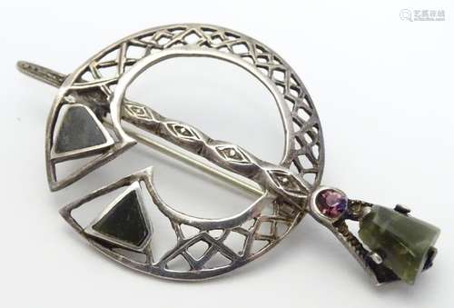 A Scottish silver brooch of penannular form set with hard-stone and amethyst detail. Indistinctly