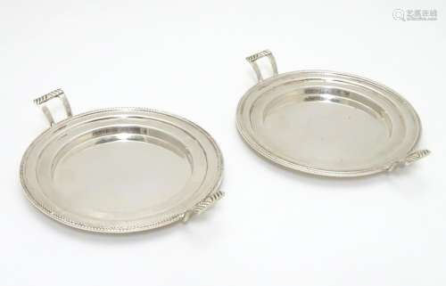 A pair of Art Deco silver coasters / stands with twin handles. Hallmarked Birmingham 1935 maker