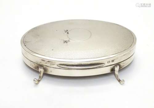 A silver ring box of oval form with engine turned decoration and on 3 feet. Hallmarked Birmingham