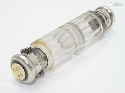 A 19thC double ended scent bottle / flask the class body with with white metal ends and yellow metal