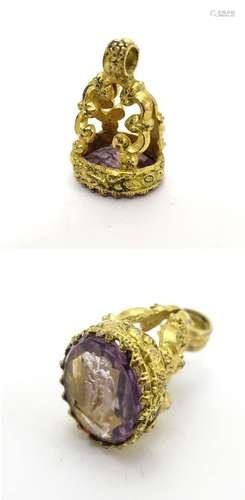 A 19thC gilt metal pendant fob seal with engraved purple stone seal under 3/4