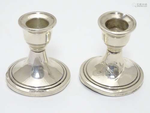 A pair of silver candlesticks hallmarked Birmingham 1962 maker Sanders & Mackenzie 2 1/2'' high