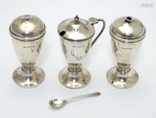 An Art Deco silver three piece cruet set comprising salt, pepper and mustard pot (with spoon and