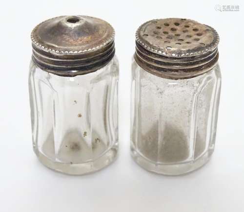 A pair of Sterling Silver lidded glass salt and pepper pots, each lid marked STERLING SILVER. Each