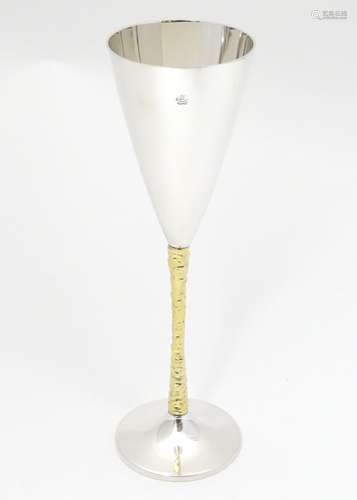 An Elizabeth II silver gilt Stuart Devlin champagne flute having flaring conical body with