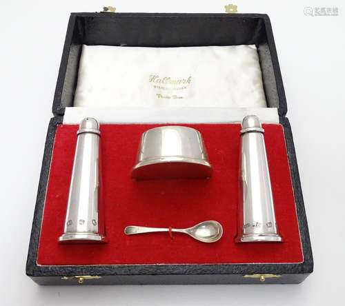 An Elizabeth II silver cruet set comprising salt, pepper and mustard, with associated spoon.