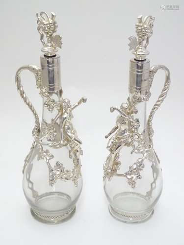 A pair of glass claret jugs / wine ewers with silver plate mounts and stopper. The whole approx. 14