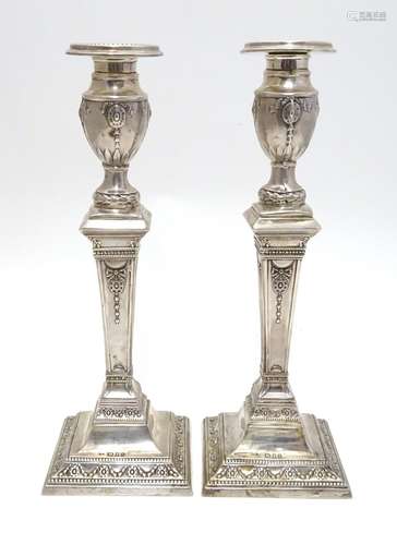 A pair of silver candlesticks hallmarked London 1931, maker Charles Kirkham. Approx. 11