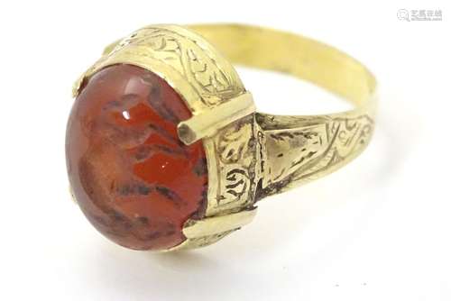 A 19thC Yellow metal ring ( tests as gold) set with carnelian cabochon with primitive carved