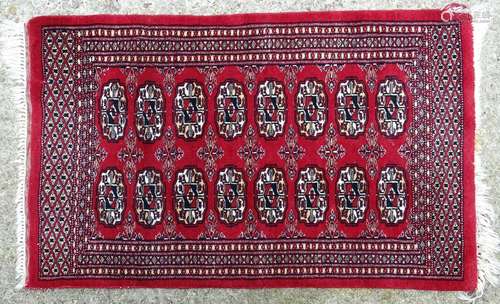 Carpet / Rug: A red ground rug with banded detail and two bands of medallion detail to centre.