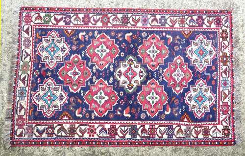 Carpet / Rug : A rug with blue ground and cream ground border, decorated with geometric vignettes