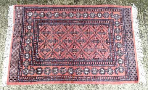 Carpet / Rug : A salmon ground rug decorated with various banded and geometric detail. Approx 65