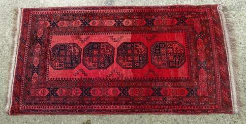 Carpet / Rug : A red ground rug with banded decoration and four central octagonal medallions. Approx