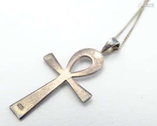 A silver celtic cross formed pendant on an 18