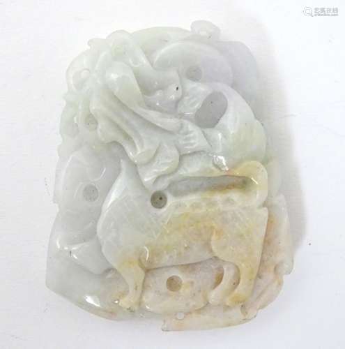 An Oriental carved jade pendant decorated with stylised dragon detail. 2 1/4