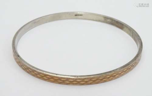 A large silver gilt bracelet / arm bracelet of bangle form with engine turned decoration. Please