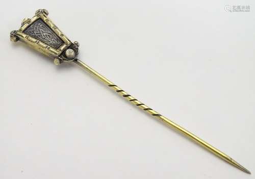 A Vintage Art Deco yellow metal stick pin, the top surmounted by a scrolling serpent decoration. The