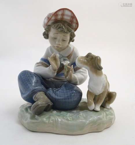 A Lladro figure of a boy with a dog pulling flower petals, I Hope She Does, model no. 5450. Marked