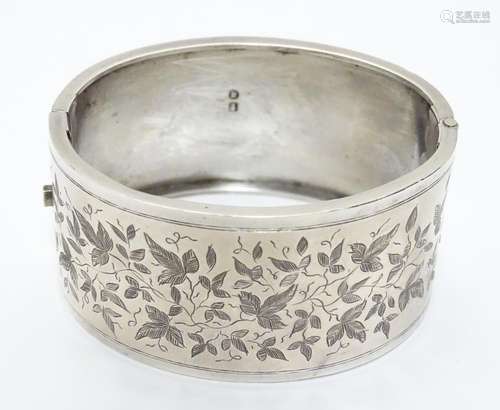 A Victorian silver bracelet of cuff bangle form with engraved decoration. hallmarked Birmingham 1884