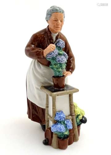 A Royal Doulton figurine depicting an old woman with flowers, Flora, model number 2349. Marked