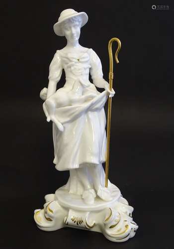 A Royal Crown Derby white glazed female figure modelled as a shepherdess, with a crook and holding