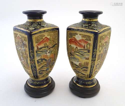 A pair of Japanese Satsuma vases of square baluster form with a cobalt blue ground, with panelled