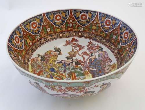 A large Japanese bowl with hand painted decoration the central roundel depicting figures / geisha