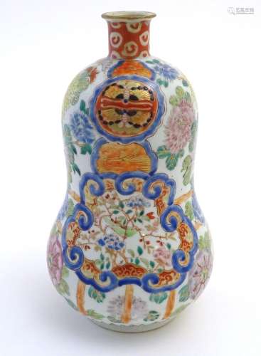 A Chinese gourd vase with famille rose decoration depicting flowers, bamboo and birds. Character