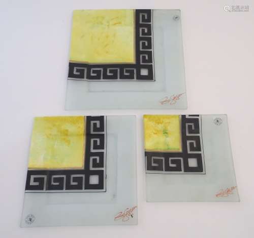 A late-20thC graduated trio of studio art glass plates, each with hand-painted greek key bordering