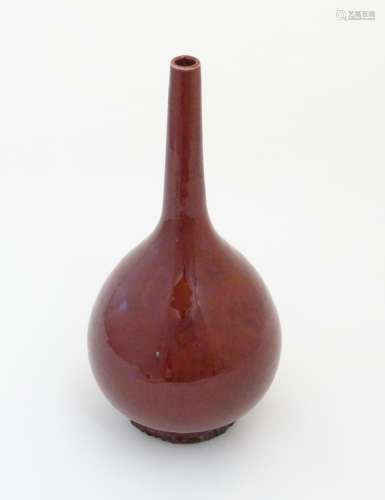 A Chinese globular vase with a slender, elongated neck with a sang de boeuf glaze. Approx. 17 1/