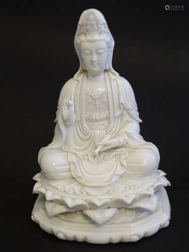 A Chinese blanc de chine figure depicting Guanyin seated on a lotus flower base. Approx. 7 1/2