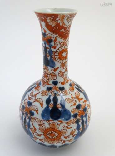 An Oriental globular vase in the Imari palette with an elongated neck with a flared rim, decorated