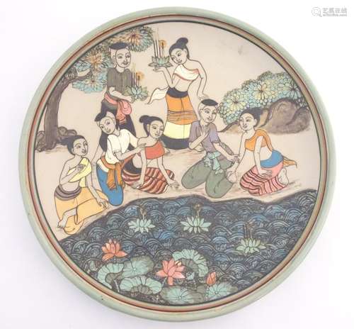 An Oriental plate, the unglazed centre decorated with a group of people in a landscape relaxing near