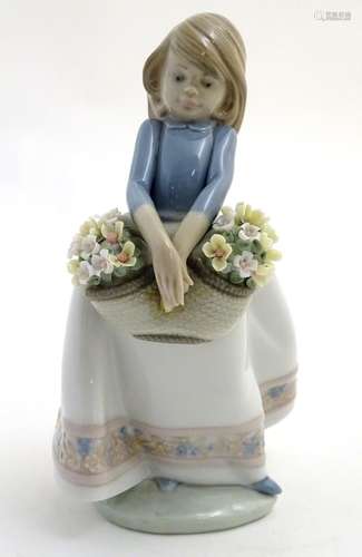 A Lladro figure of a girl with a basket of flowers, May Flowers Girl, model no. 5467. Marked