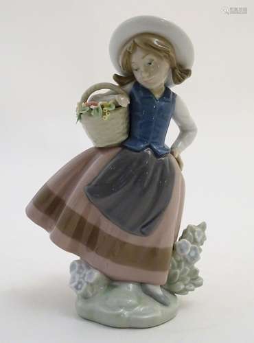 A Lladro figure of a girl holding a basket of flowers, Sweet Scent, model no. 5221. Marked under.