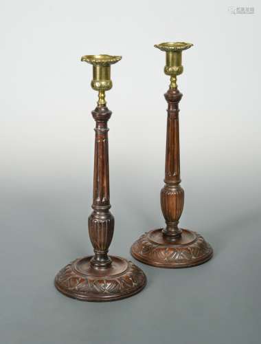A pair of turned and carved columnar candlesticks,