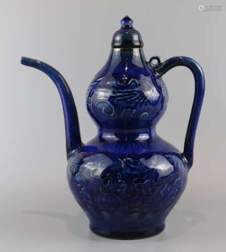 Gourd wine pot with dark carved dragon and phoenix patterns in sapphire blue glaze