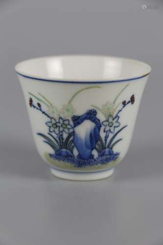 A BLUE AND WHITE CUP WITH FLOWERS AND FRUITS PATTERNS