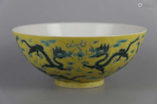 A BOWL WITH GREEN DRAGON PATTERNS ON YELLOW BACKGROUND