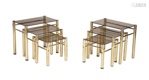 A pair of metal and glass nests of three occasional tables