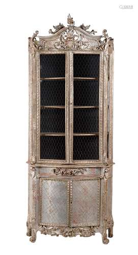 A Continental carved and silver painted display cabinet