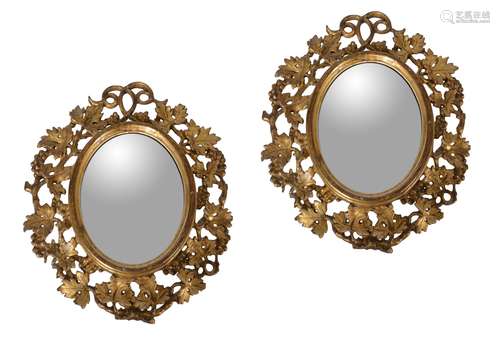 A pair of small carved giltwood oval wall mirrors