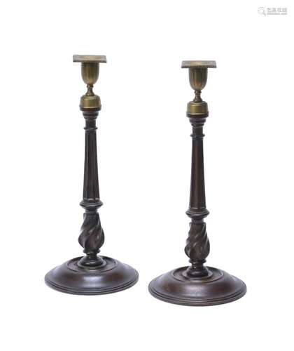 A pair of late George III turned mahogany and brass mounted candlesticks