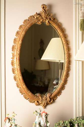 A carved giltwood oval wall mirror in George III style